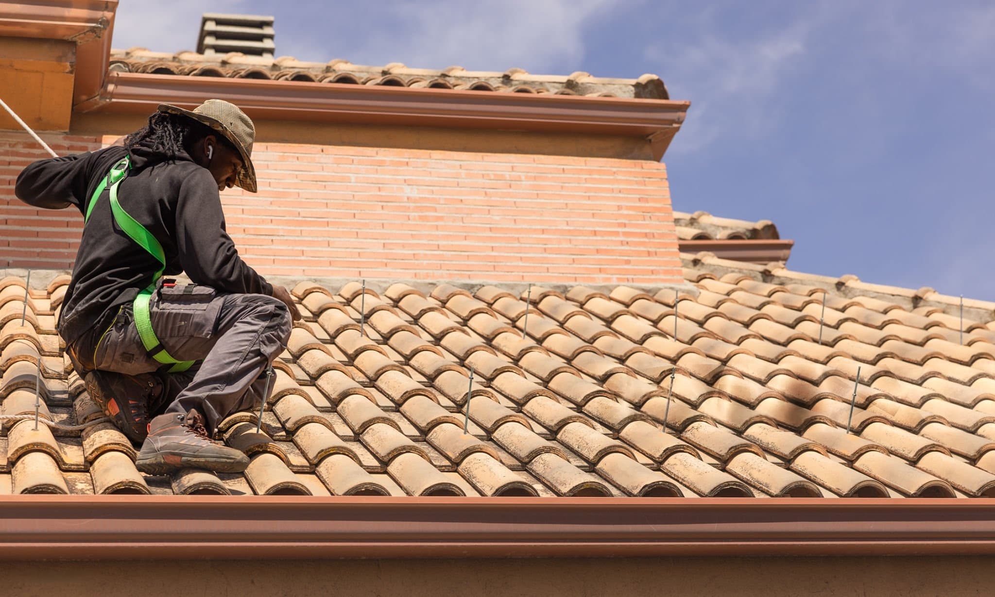 A roofer replacing roof tiles